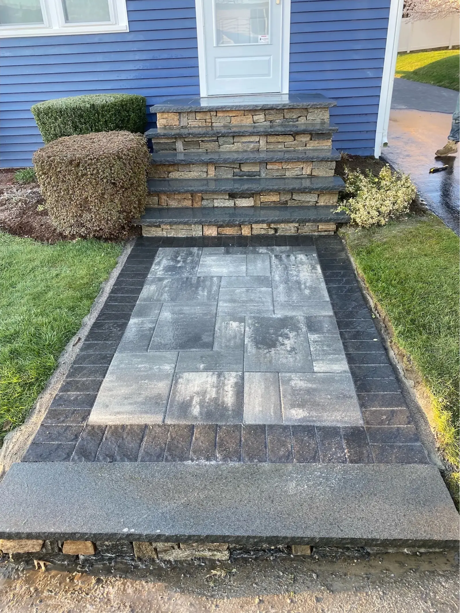 Bluestone walkway leading to stone veneer front entry stairs